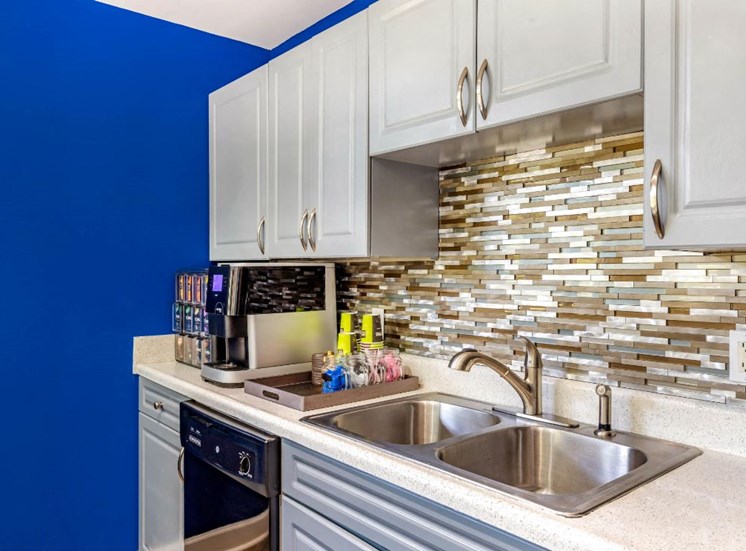 Clubhouse Kitchen with Blue Accent Wall and White Cabinets